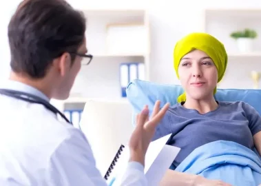 Doctor sitting down and talking with cancer patient